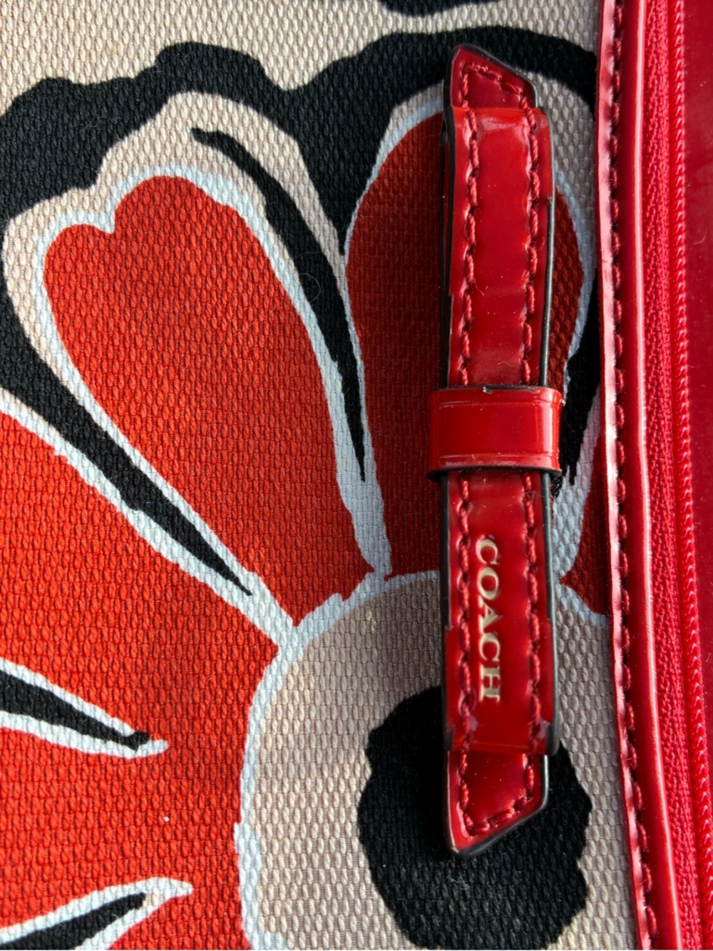 COACH Red Floral Canvas Wristlet with Tan Background